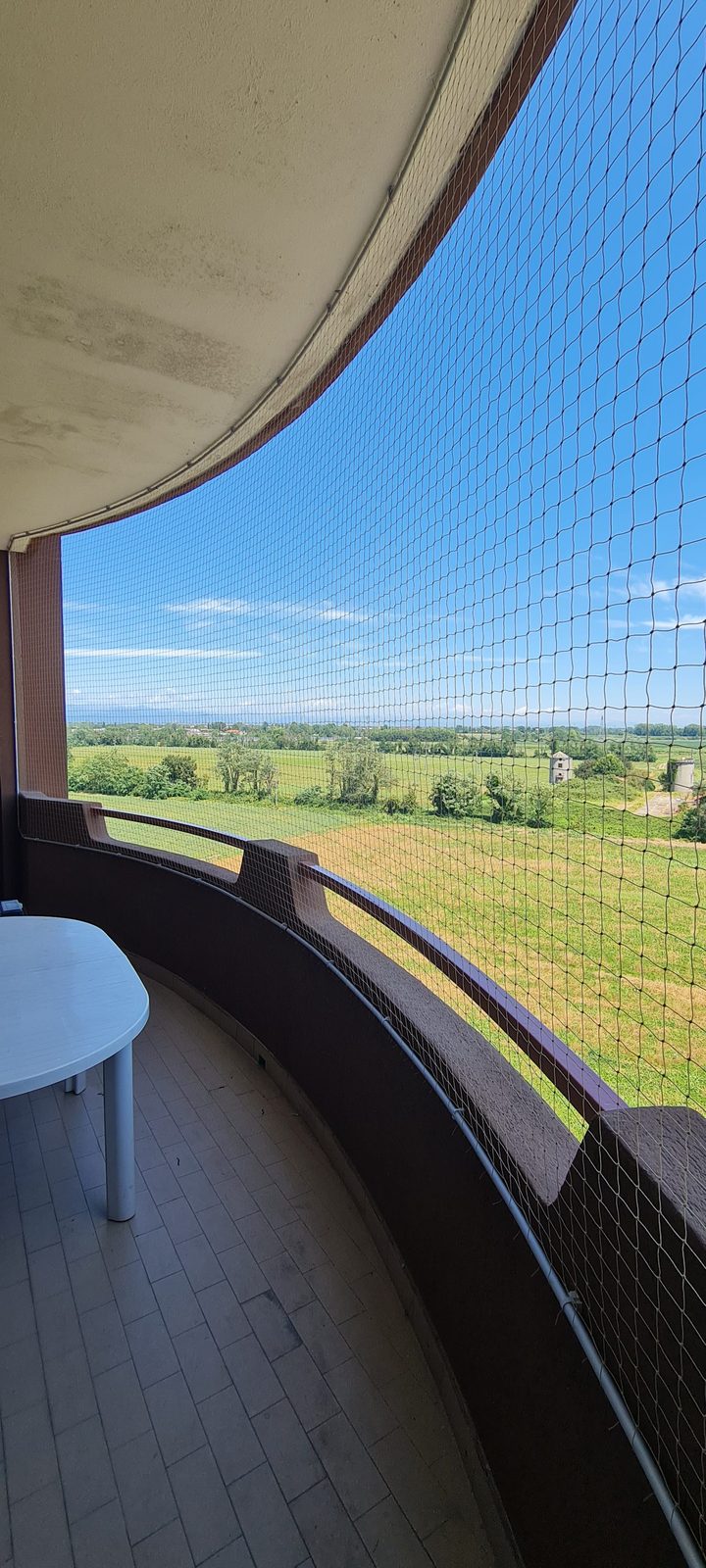 Balcone curvo con rete in nylon e telaio in alluminio, vista panoramica
