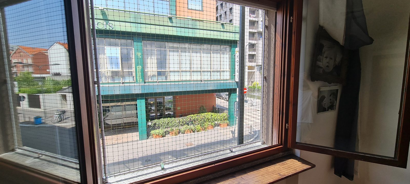 Finestra con rete trasparente che mantiene la vista sul cortile