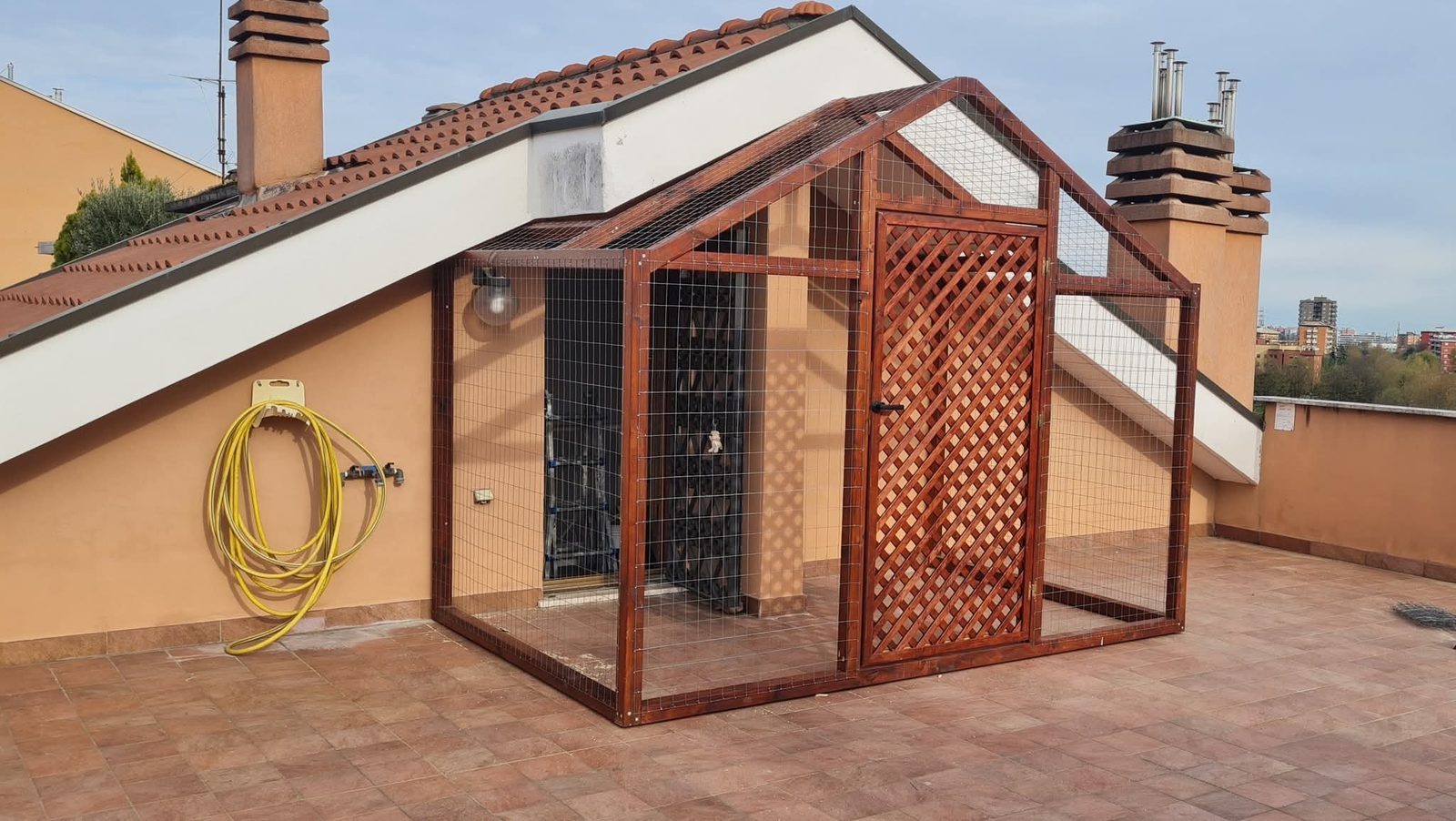 Struttura in legno autoclavato color mogano su terrazzo, con rete metallica